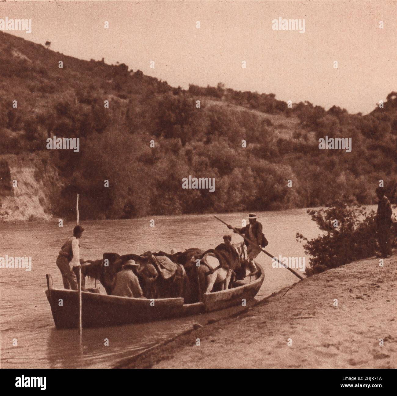 Pittoresco traghetto, mezza barca, mezza chiatta, che attraversa il fiume Alpheus, dove costeggia le pendici boscose di Olympia. Grecia (1923) Foto Stock
