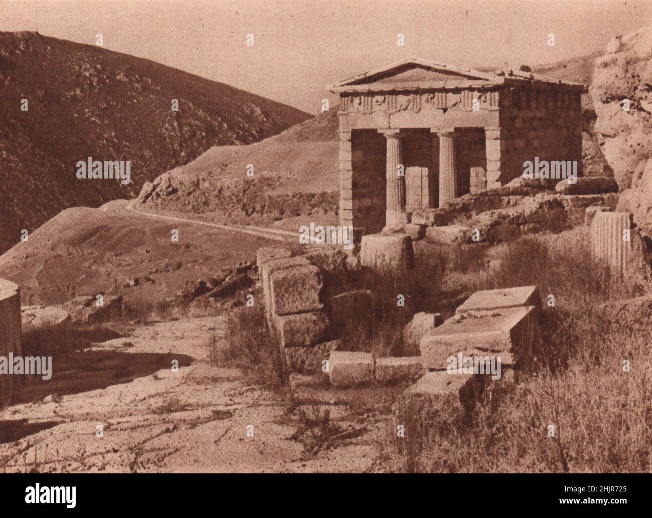 Tra le meravigliose rovine di Delfi si trova l'edificio dorico conosciuto come il Tesoro degli Altheni, con le sue metope scolpite. Grecia (1923) Foto Stock
