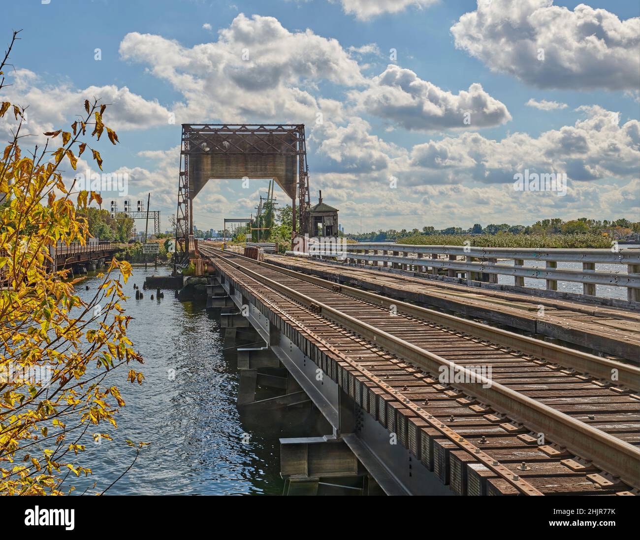 Una lunga vista prospettica di un vecchio ponte ferroviario a bastone, noto anche come ponte levatoio o ponte di sollevamento, con un contrappeso. Foto Stock