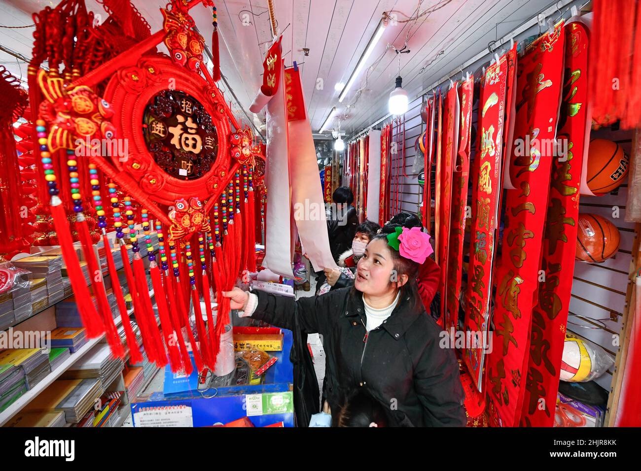 (220131) -- KAILI, 31 gennaio 2022 (Xinhua) -- Yang Mei acquista merci per il prossimo Festival di Primavera a Kaili, provincia di Guizhou della Cina sudoccidentale, 30 gennaio 2022. Il villaggio di Kaishao, la città natale del ricamatore Yang Mei, era impoverito a causa del suo terreno povero e delle limitate condizioni di trasporto. Un sacco di abitanti del villaggio qui ha scelto di lavorare come lavoratori immigrati in altri luoghi. Nel 2016, grazie alle politiche locali di riduzione della povertà, la famiglia di Yang Mei ha avuto la possibilità di trasferirsi nella loro nuova casa in un sito di trasferimento a Kaili. Con l'aiuto di sessioni di formazione professionale e di sostegno da parte del governo, Yan Foto Stock