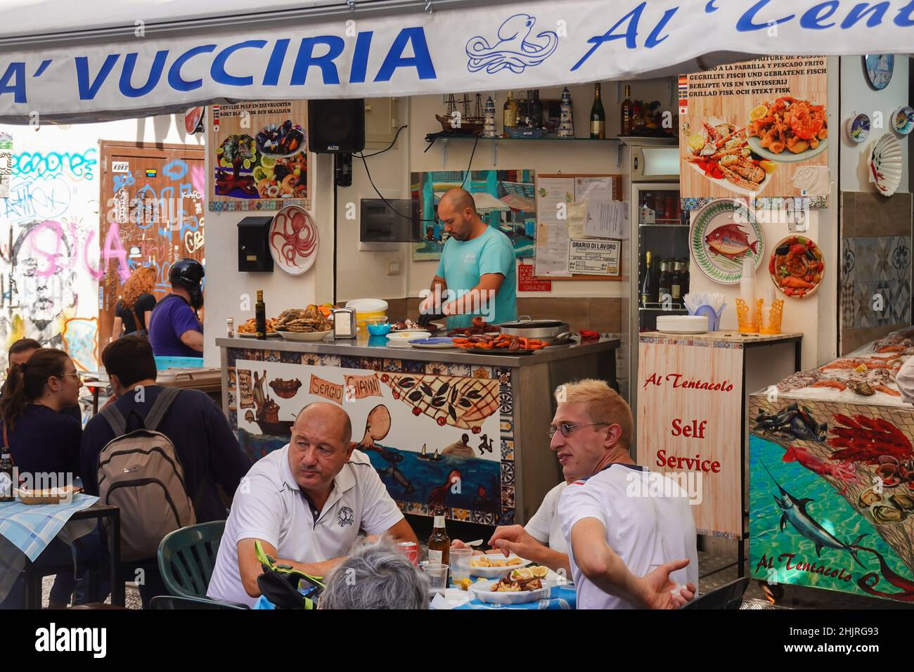 Palermo, Italia - Ottobre 23 2021: I locali mangiano frutti di mare in un ristorante dello storico mercato della Vucciria a Palermo, nella più grande città della Sicilia. T Foto Stock