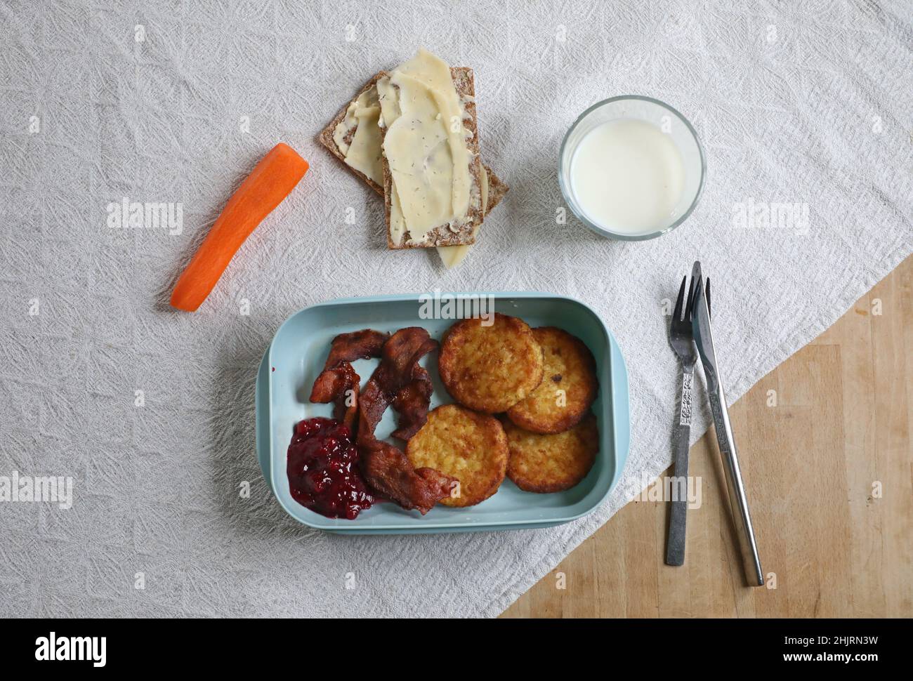 Gennaio è il mese povero non ufficiale dell'anno. Qui c'è qualcuno che mangia focaccine di patate, pancetta con carota, croccante svedese e un bicchiere di latte per pranzo. Foto Stock