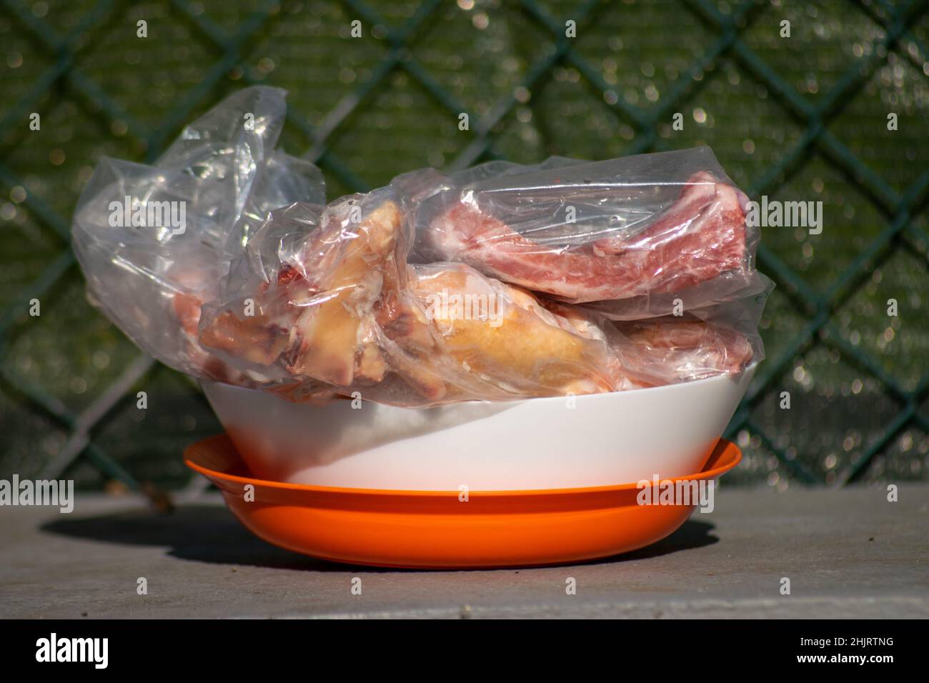 Scongelamento della carne al sole. Carne in un sacchetto di plastica scongelata al sole. Foto Stock
