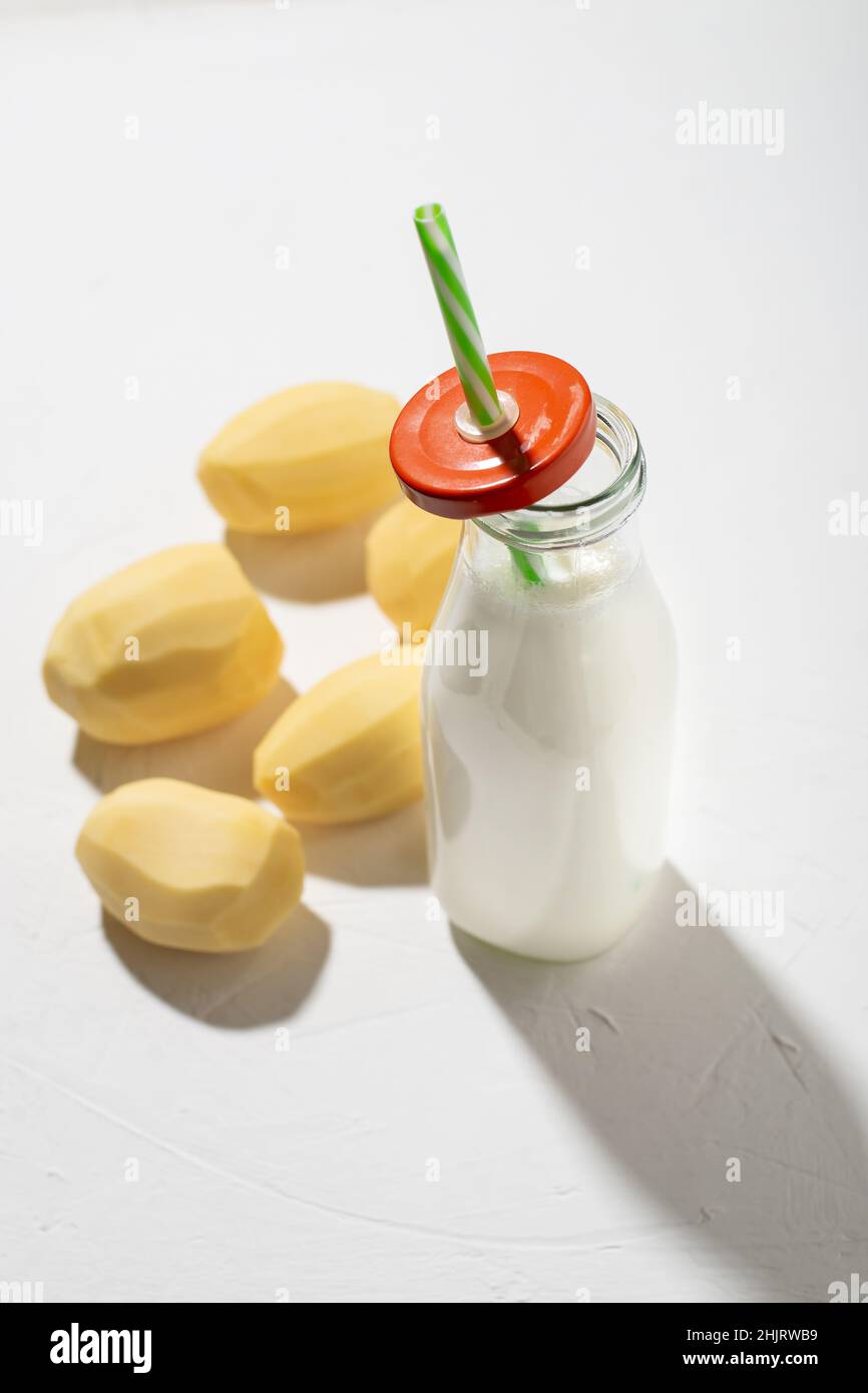 Concetto di latte di patate. Bottiglia con latte di patate su sfondo bianco. Un'alternativa ai prodotti animali. Cibo vegano. Foto Stock