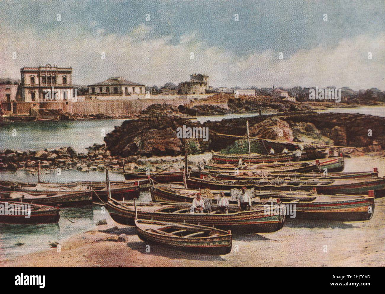 Strani disegni in colori fantastici sono stati dipinti sulle gunwales di queste barche disegnate sulla spiaggia di Aci Castello. Italia. Sicilia (1923) Foto Stock