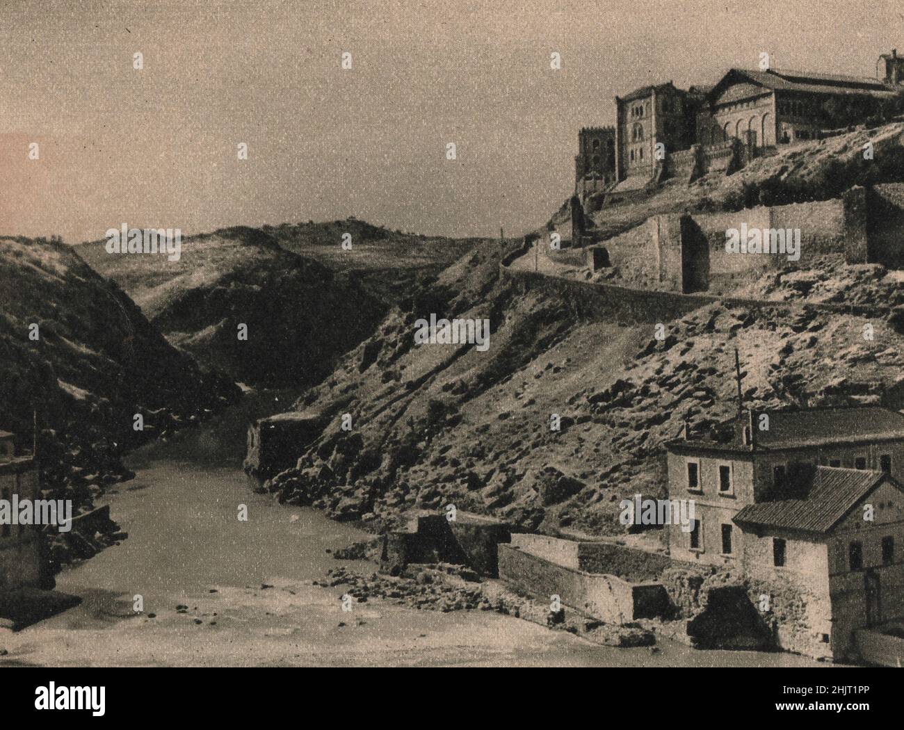 Sotto la scogliera rocciosa su cui si erge Toledo, il Tago attraversa una profonda gola che abbraccia la città su tre lati. Spagna (1923) Foto Stock