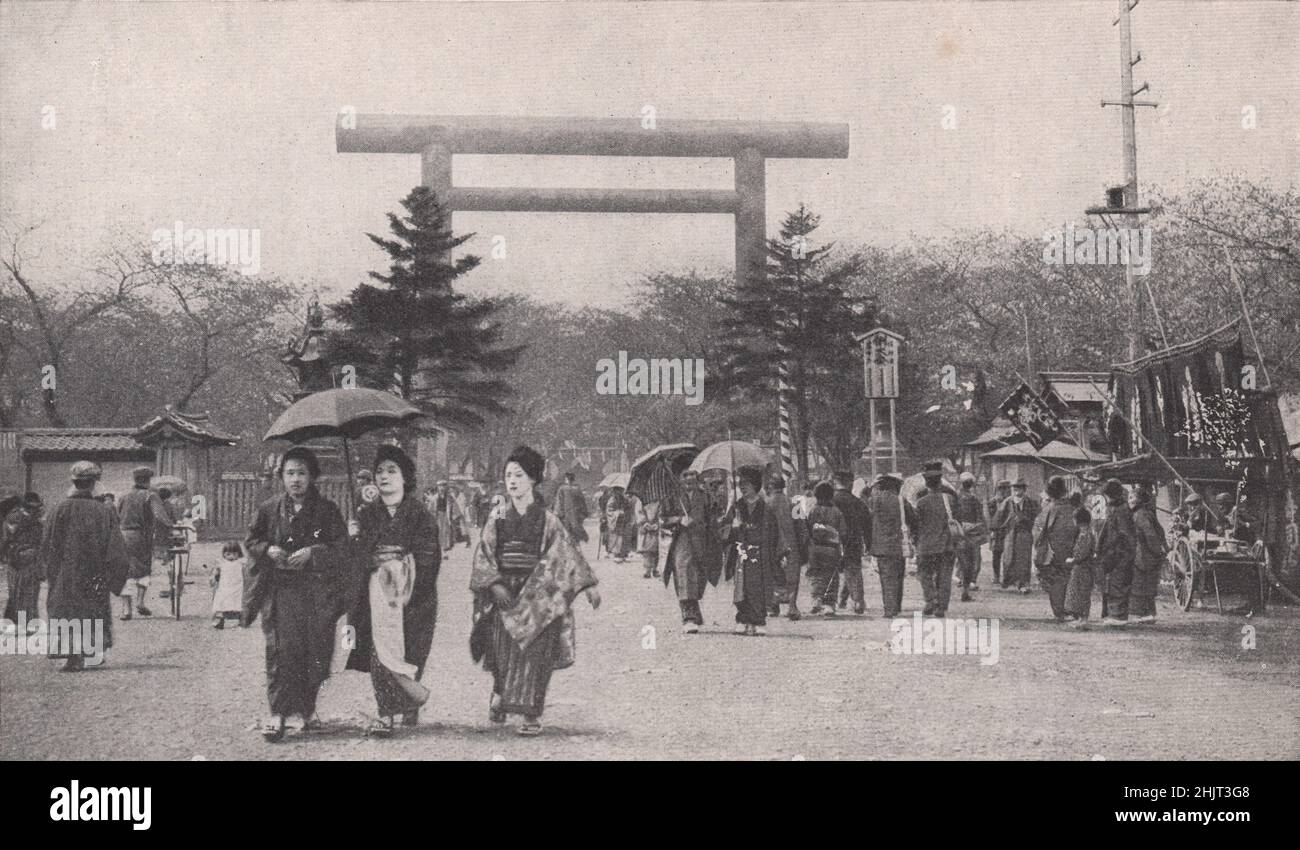 La vita quotidiana passa sotto l'enorme Torii Bronzo vicino al Tempio Shinto sulla collina di Kudan. Giappone. Tokyo (1923) Foto Stock