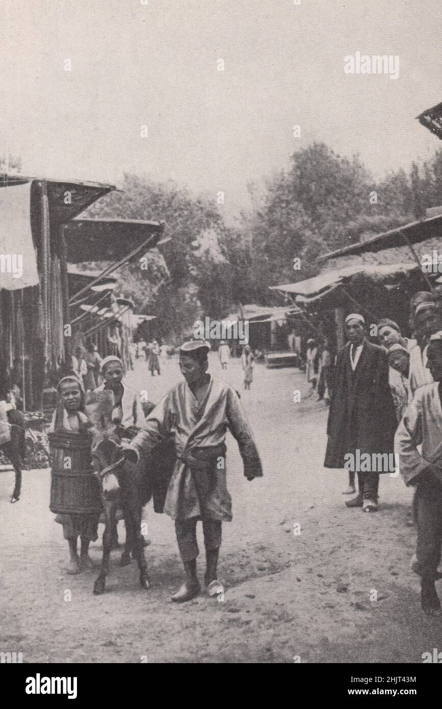 Vettore d'acqua in una Business Street di Kashgar. Cina. Asia Centrale (1923) Foto Stock
