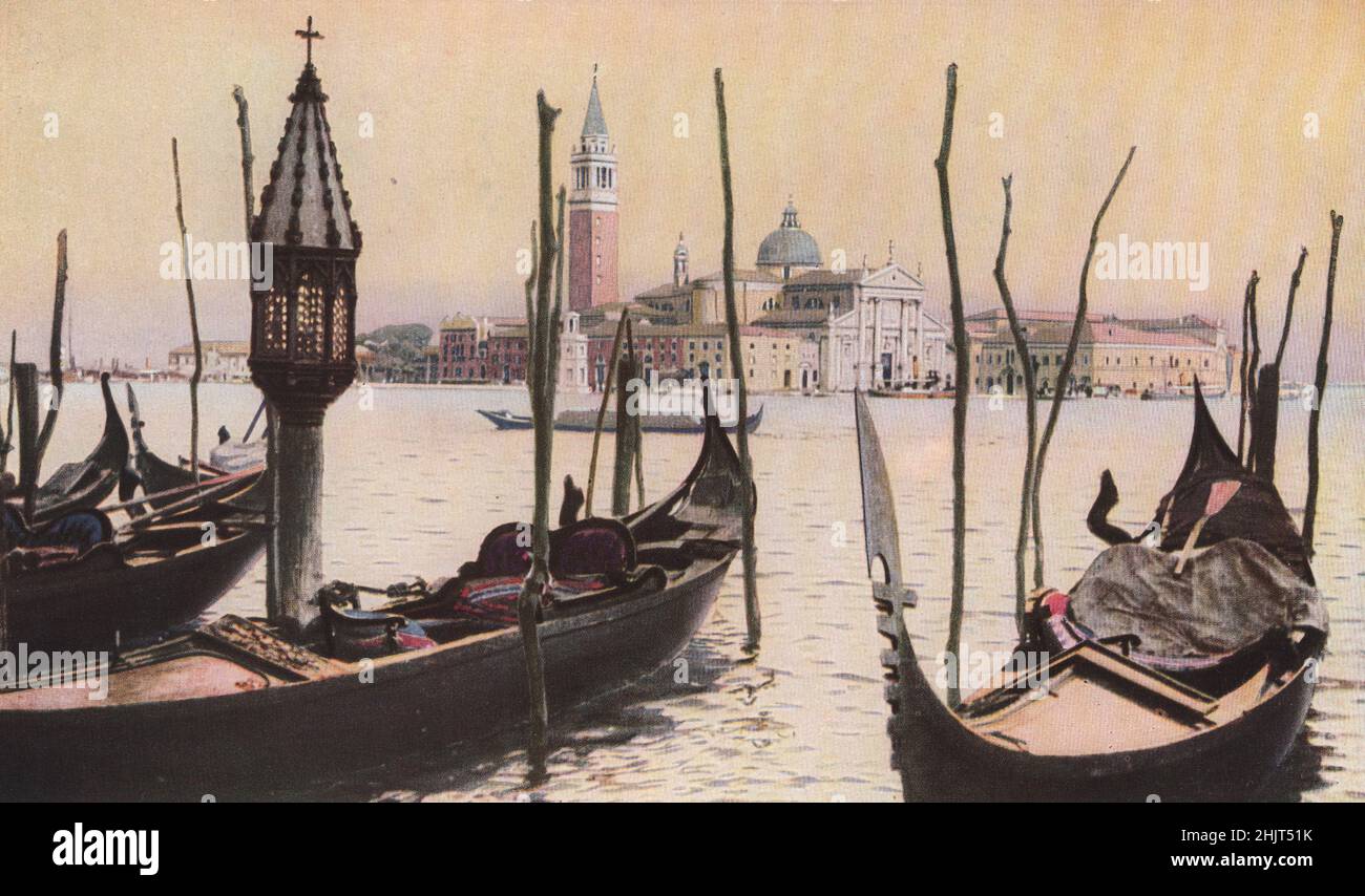Guardando dal Molo tra le postazioni di ormeggio delle gondole con i loro santuari lanterna si vede l'isola di San Giorgio. Venezia (1923) Foto Stock