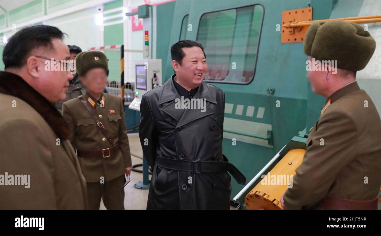 KIM JONG-un leader nordcoreano in visita a una fabbrica di munizioni dicembre 2021. I funzionari si affacciano oscurati dal censore. Foto Stock