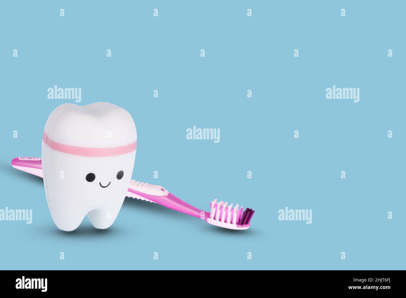 Spazzolino e dente bianco su sfondo blu chiaro. Concetto creativo di denti per esami dentali, salute e igiene dentale. Spazio di copia. Foto Stock