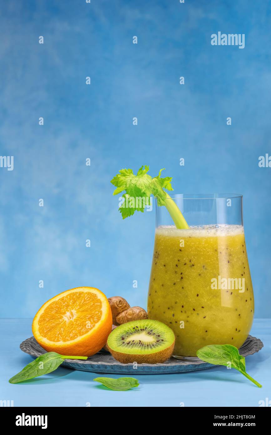 Bicchiere di spinaci verdi, arancia, zenzero e kiwi sani frullati. Foto Stock
