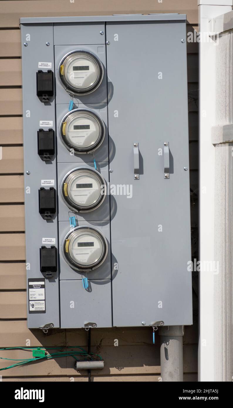 Colpo verticale di misuratori elettrici di condo montati su una parete. Foto Stock