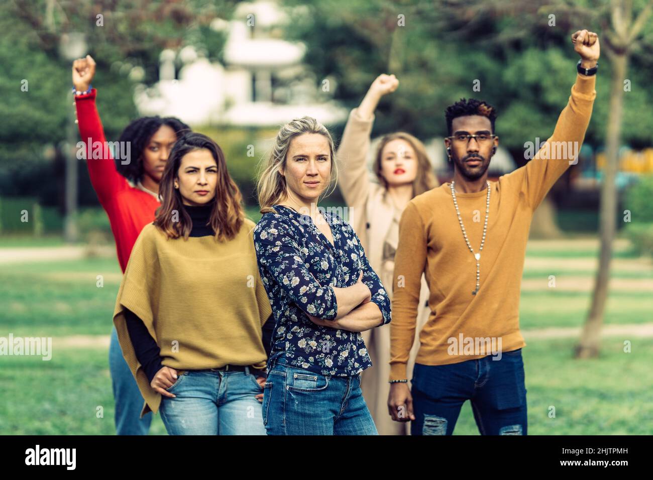 donna seria con le sue braccia piegate conduce un gruppo di persone donna seria con le sue braccia piegate conduce un gruppo di persone Foto Stock