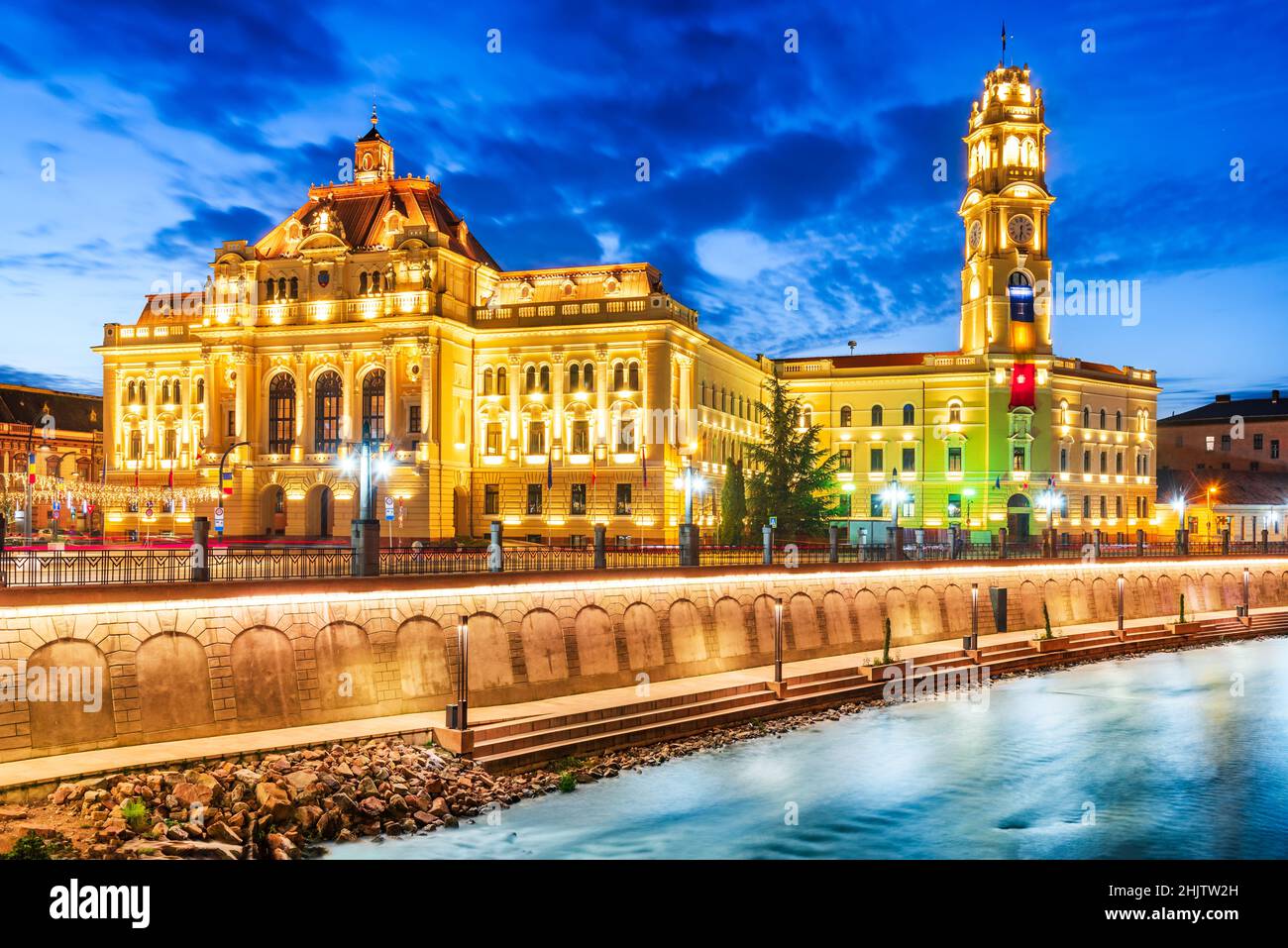 Oradea, Romania. Bel crepuscolo con il fiume Cris e il municipio. Foto Stock