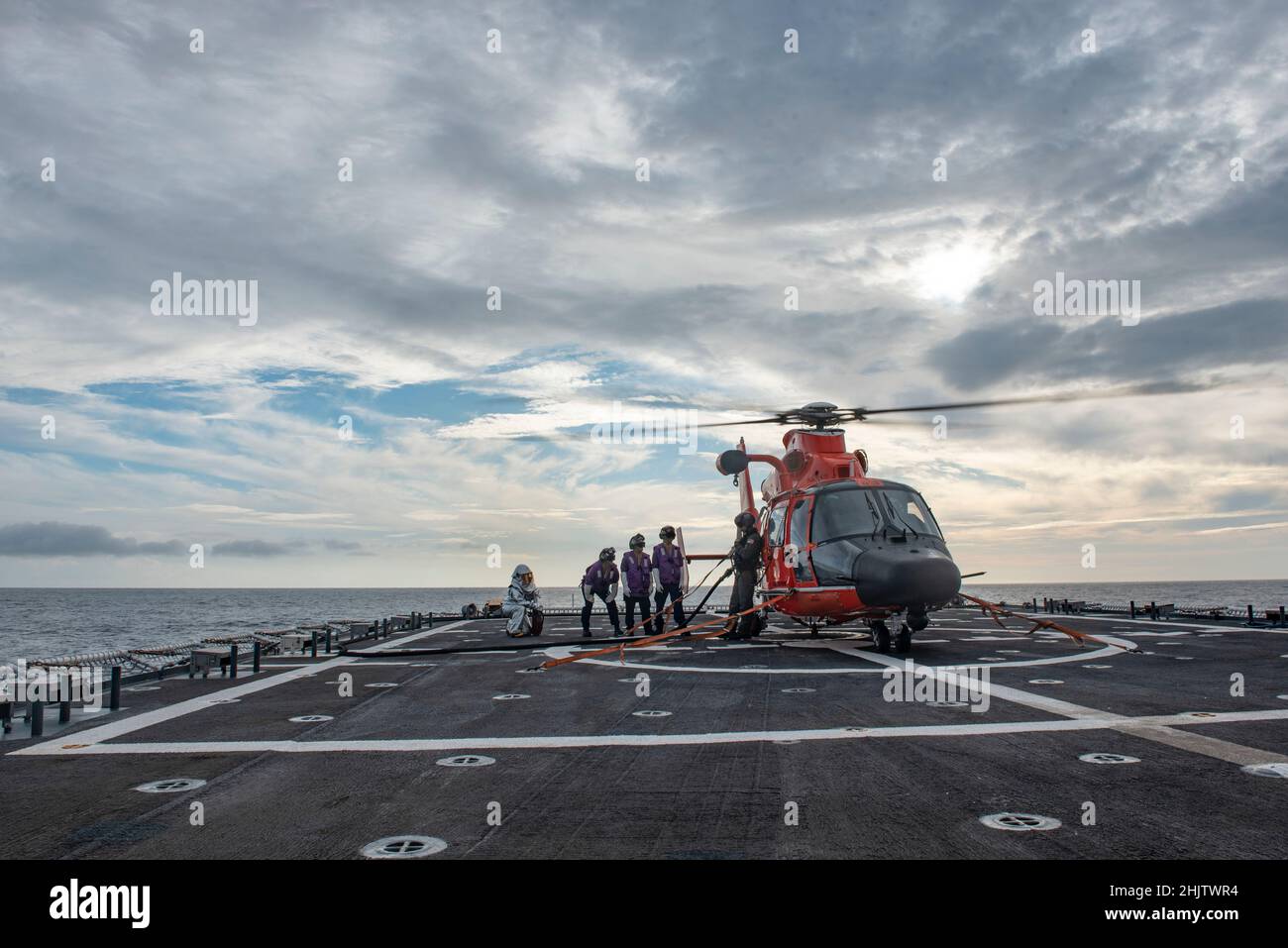 I membri dell'equipaggio della USCGC Stratton (WMSL 752) rifornire un elicottero MH-65E Dolphin nell'Oceano Pacifico, 2 gennaio 2022. L'equipaggio di Stratton ha condotto operazioni di volo per mantenere le capacità operative e aumentare la prontezza. (STATI UNITI Foto della Guardia Costiera degli Stati Uniti Marine Corps Sgt. Sarah Stegall) Foto Stock