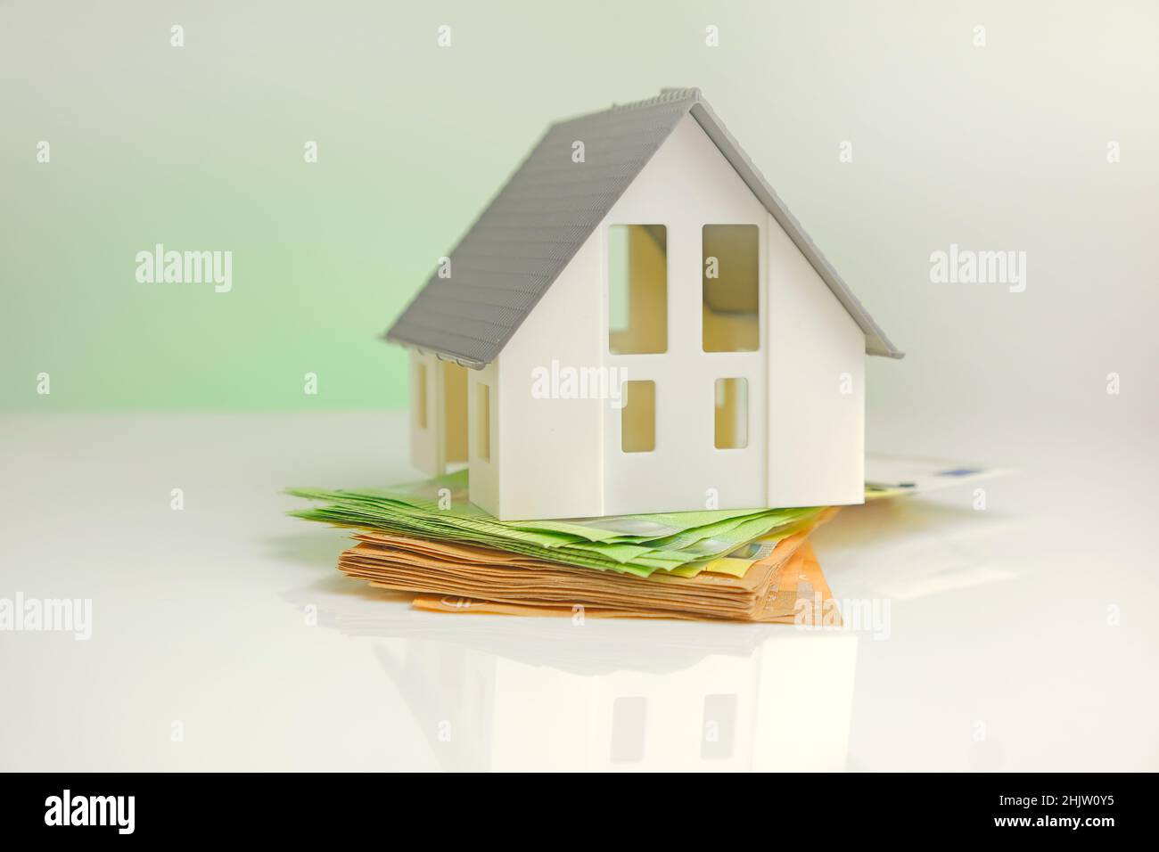 Acquisto e costruzione di una casa. Casa e soldi. Mercato immobiliare. Casa con tetto grigio su banconote in euro Foto Stock