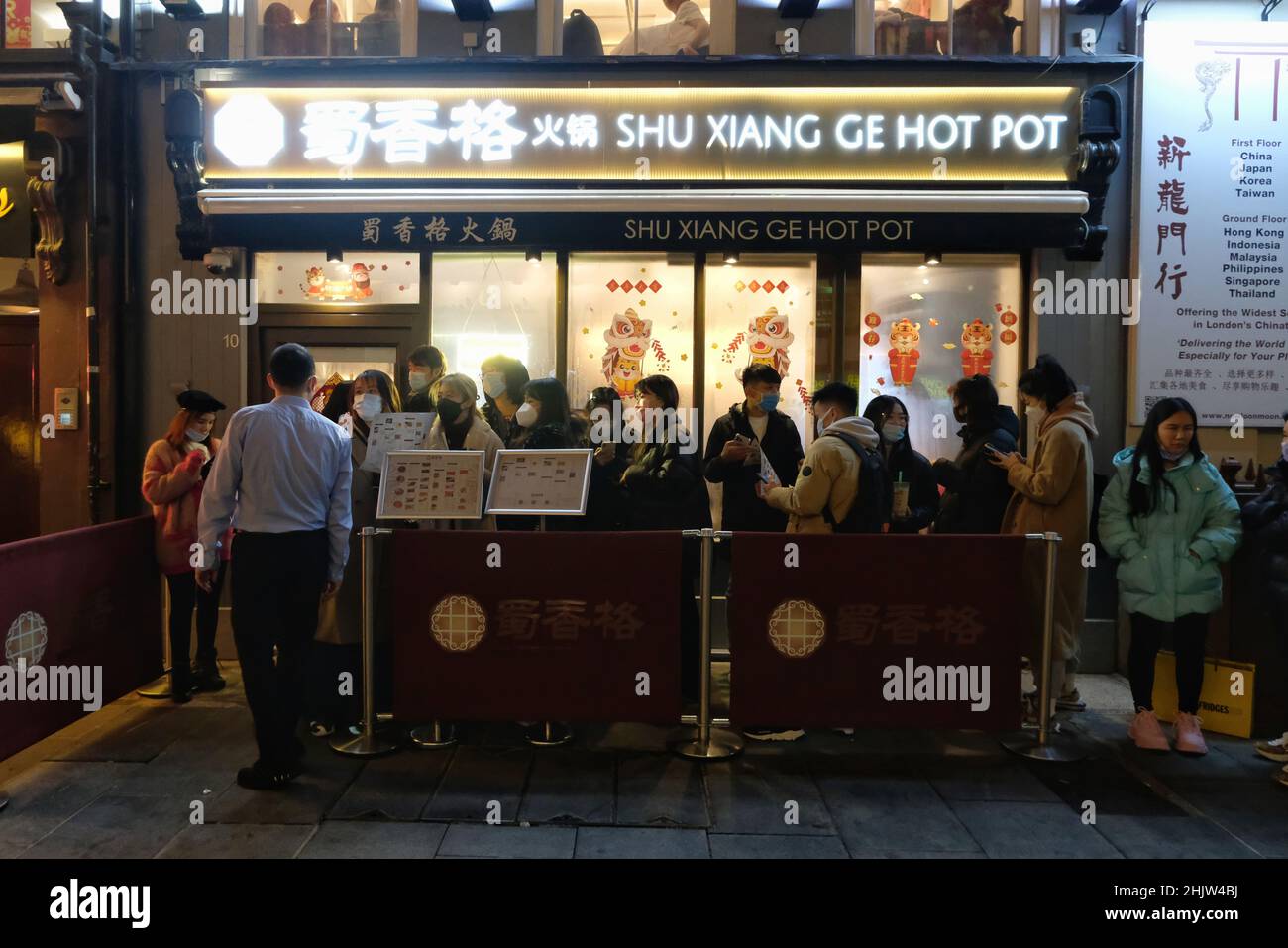 Londra, Regno Unito, 31st gennaio, 2022. Il cliente aspetta pazientemente fuori dal ristorante Shu Xiang GE Hot Pot per una cena di Capodanno cinese. A Chinatown si è tenuta una celebrazione in scala ridotta per il Capodanno lunare dopo la cancellazione della sfilata annuale per il secondo anno consecutivo a causa di problemi di pianificazione pandemica di Covid. I visitatori hanno goduto di una danza del leone e di un mercato notturno, con bancarelle che offrono cibo di strada, coppie cinesi, regali e molto altro, per il benvenuto nell'anno della Tigre. Credit: Undicesima ora Fotografia/Alamy Live News Foto Stock