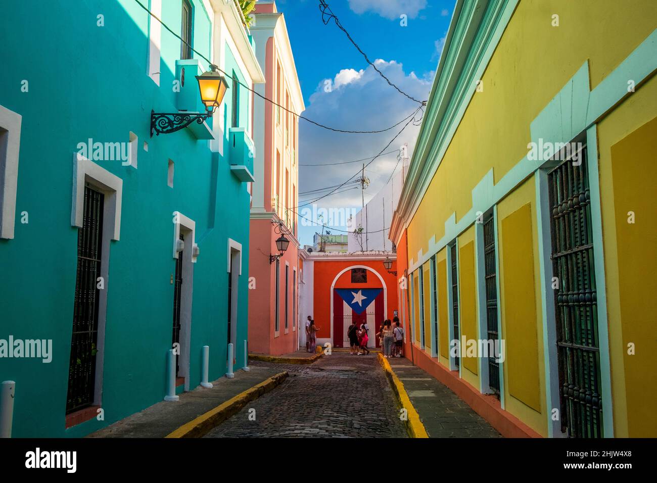Turisti vicino ad un murale della bandiera di Puerto Rico in una strada piena di case colorate, Old San Juan, Porto Rico Foto Stock