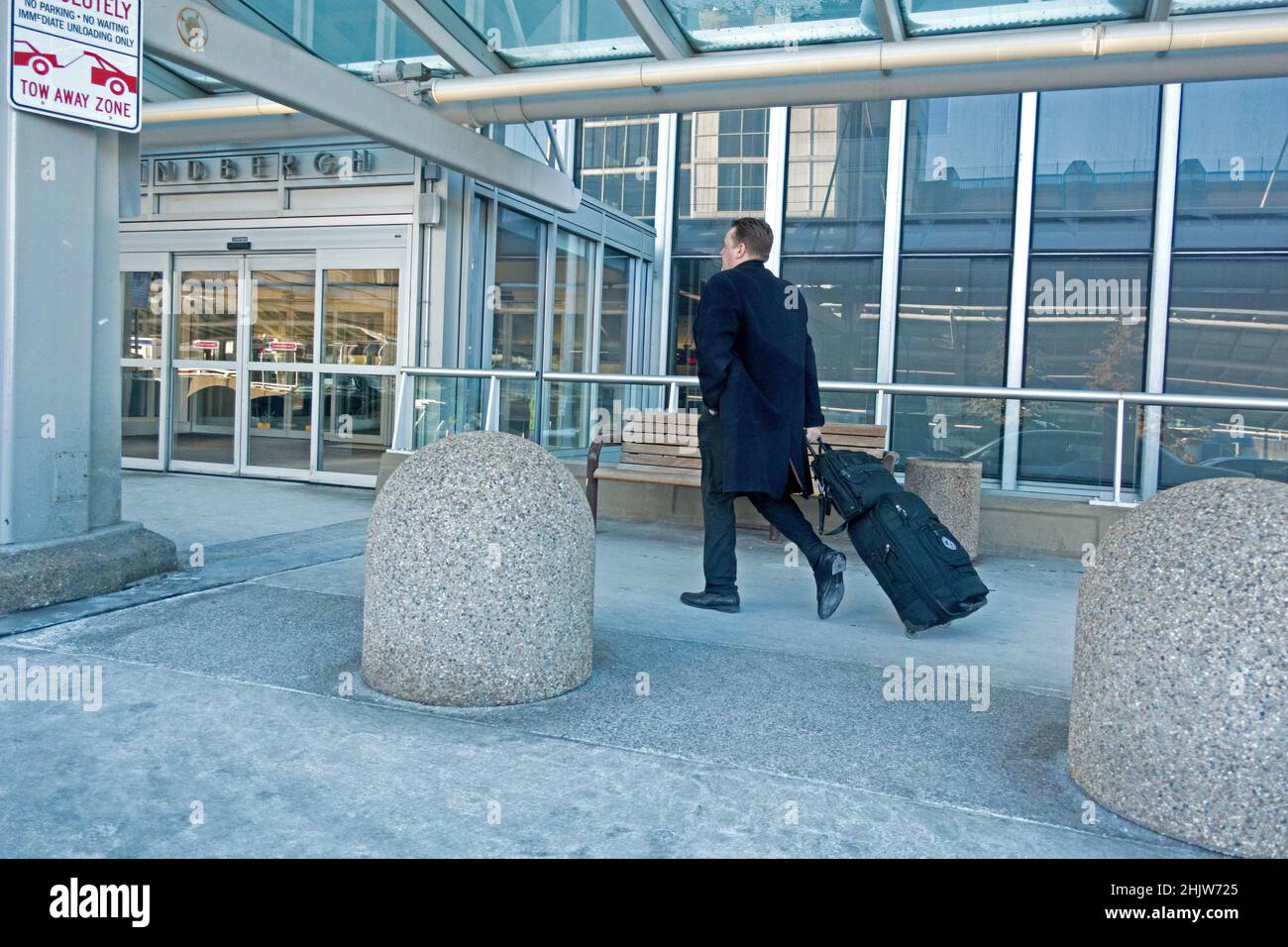 L'uomo con i randelli di golf che lasciano su un aeroplano per i climi più caldi all'Aeroporto Internazionale St Paul di Minneapolis. Minneapolis Minnesota, Stati Uniti Foto Stock