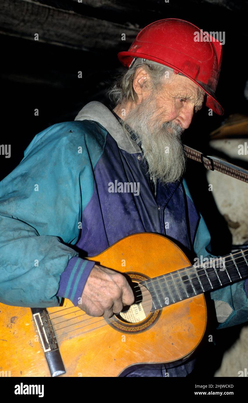 Dugout Dick, famoso eremita dell'Idaho di 86 anni, suona la sua chitarra nella sua grotta nel 2002 sul fiume Salmon nell'Idaho centrale. Morì nel 2010 all'età di 94 anni. Foto Stock