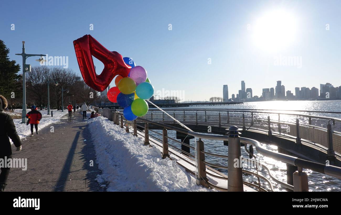 Il compleanno di un bambino del 4th è celebrato nel parco del fiume Hudson di New York City nel villaggio di Greenwich il giorno dopo una tempesta di neve. Foto Stock
