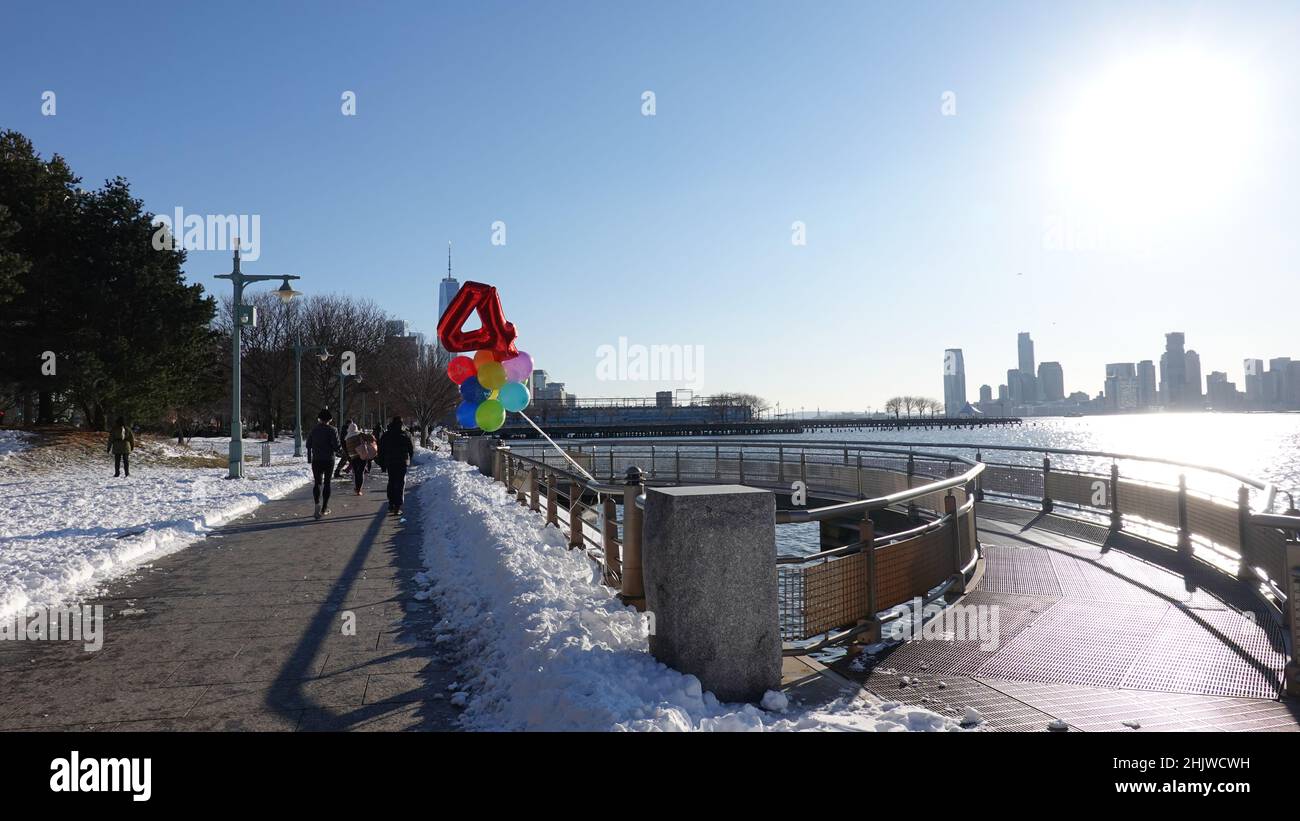 Il compleanno di un bambino del 4th è celebrato nel parco del fiume Hudson di New York City nel villaggio di Greenwich il giorno dopo una tempesta di neve. Foto Stock