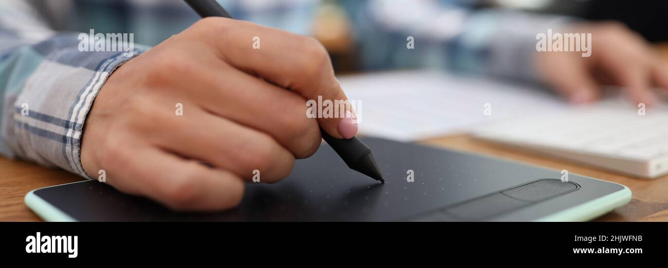 Editor grafico ritocco di disegni su tavoletta grafica in studio Foto Stock