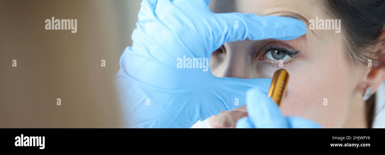 Il medico illumina l'occhio del paziente per controllare il primo piano della pupilla Foto Stock