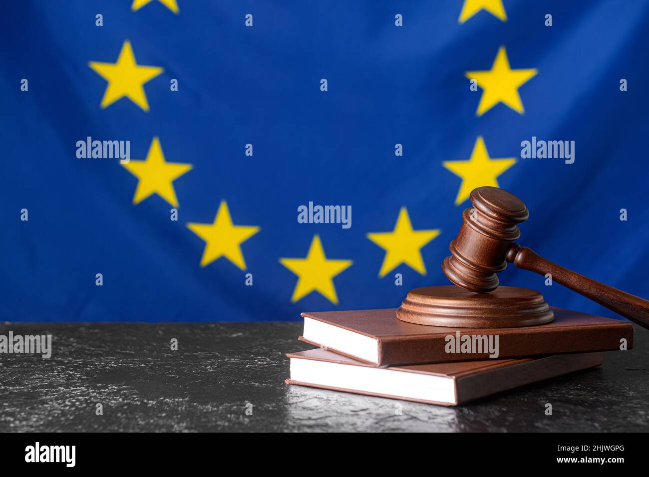 Gavel di giudice con libri contro la bandiera dell'Unione europea Foto Stock