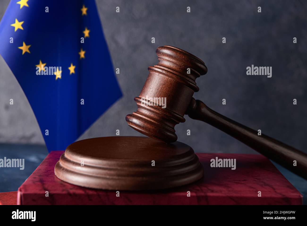 Gavel di giudice con libro e bandiera dell'Unione europea su sfondo scuro Foto Stock