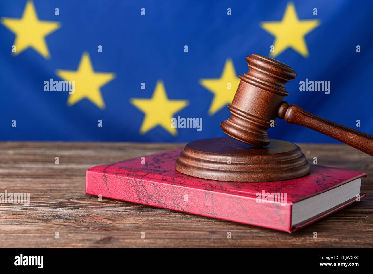 Gavel di giudice con libro contro la bandiera dell'Unione europea Foto Stock