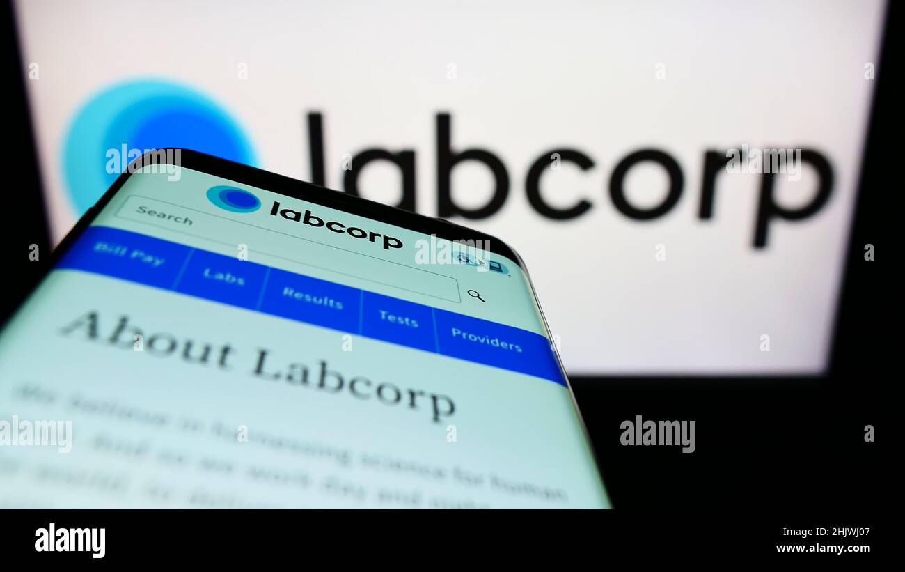 Smartphone con sito Web della società di laboratorio statunitense Labcorp sullo schermo di fronte al logo aziendale. Mettere a fuoco sulla parte superiore sinistra del display del telefono. Foto Stock