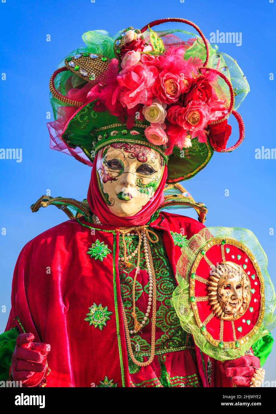 Donna in coloratissimo costume storico, cappello e maschera pone al Carnevale di Venezia, Carnivale di Venezia, Veneto, Italia Foto Stock