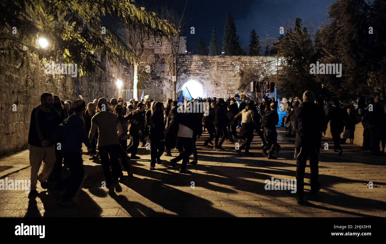 Gli ebrei religiosi danzano di fronte a Bab al-Asbat (la porta delle tribù) durante la celebrazione del 'Sajuv Shaarim' (Circling of the Gates) intorno alle porte del Monte del Tempio il 31 gennaio 2022 a Gerusalemme, Israele. L'evento si svolge ogni primo giorno del nuovo mese nel calendario ebraico. Durante la cerimonia, gli adoratori circondano il Monte del Tempio, cantando e ballando mentre passano ciascuna delle sue porte. Foto Stock
