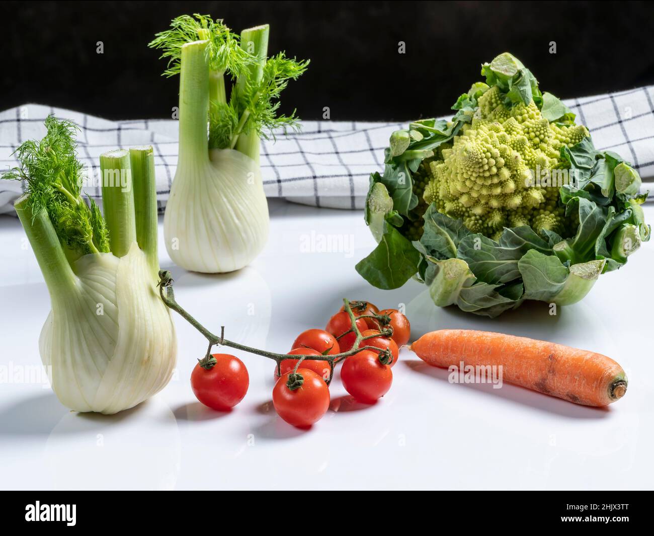 Composizione di verdure fresche con cavolo romano, carota, pomodori ciliegini e finocchio Foto Stock