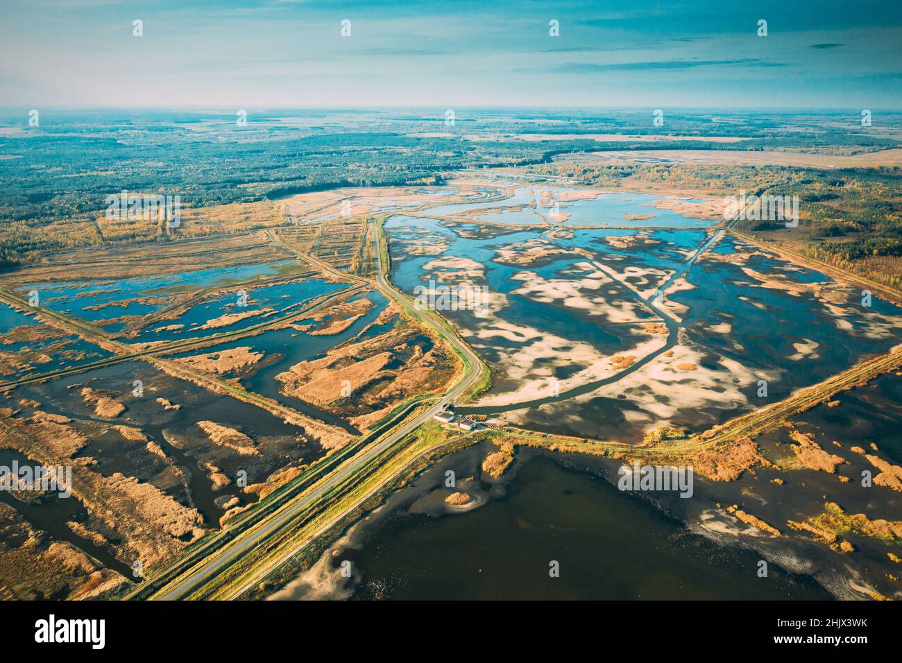 La Bielorussia. Vista aerea della strada attraverso stagni nel paesaggio autunnale. Stagni di pesca nel Sud della Bielorussia. Vista dall'alto di allevamenti ittici dall atteggiamento di alta. Foto Stock