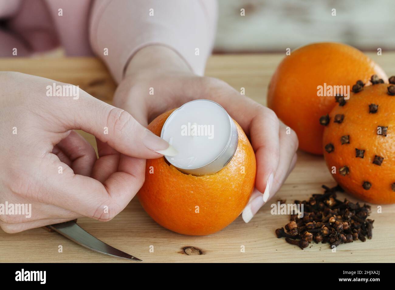 Donna mostra come fare la palla di pomander arancione con candela - passo  dopo passo, tutorial Foto stock - Alamy