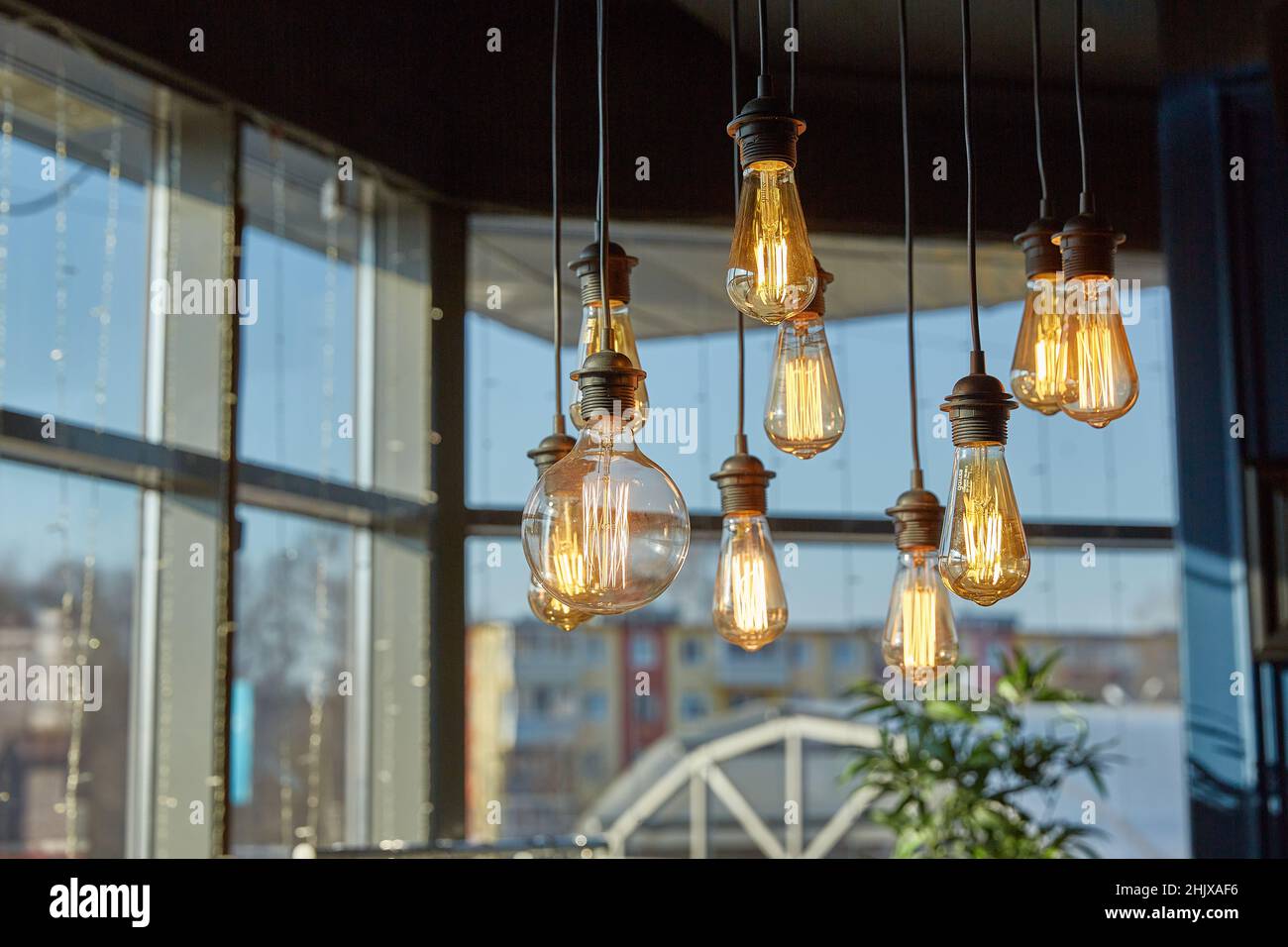 Le lampade decorative da soffitto illuminano una luce soffusa nella foto di una grande finestra. Decorazione della casa ed elementi interni Foto Stock