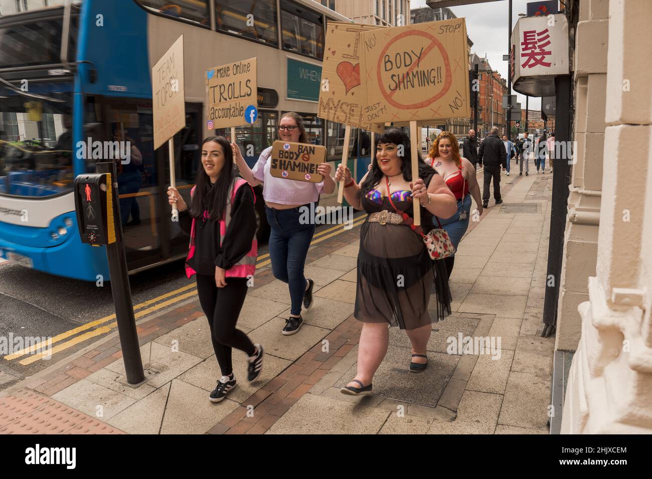 Protettori di positività del corpo che marciano lungo la strada con cartelli. Manchester, Regno Unito. Foto Stock