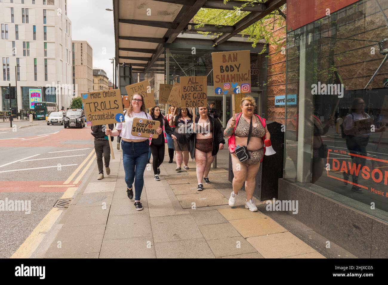 Protettori di positività del corpo che marciano lungo la strada con cartelli. Manchester, Regno Unito. Foto Stock