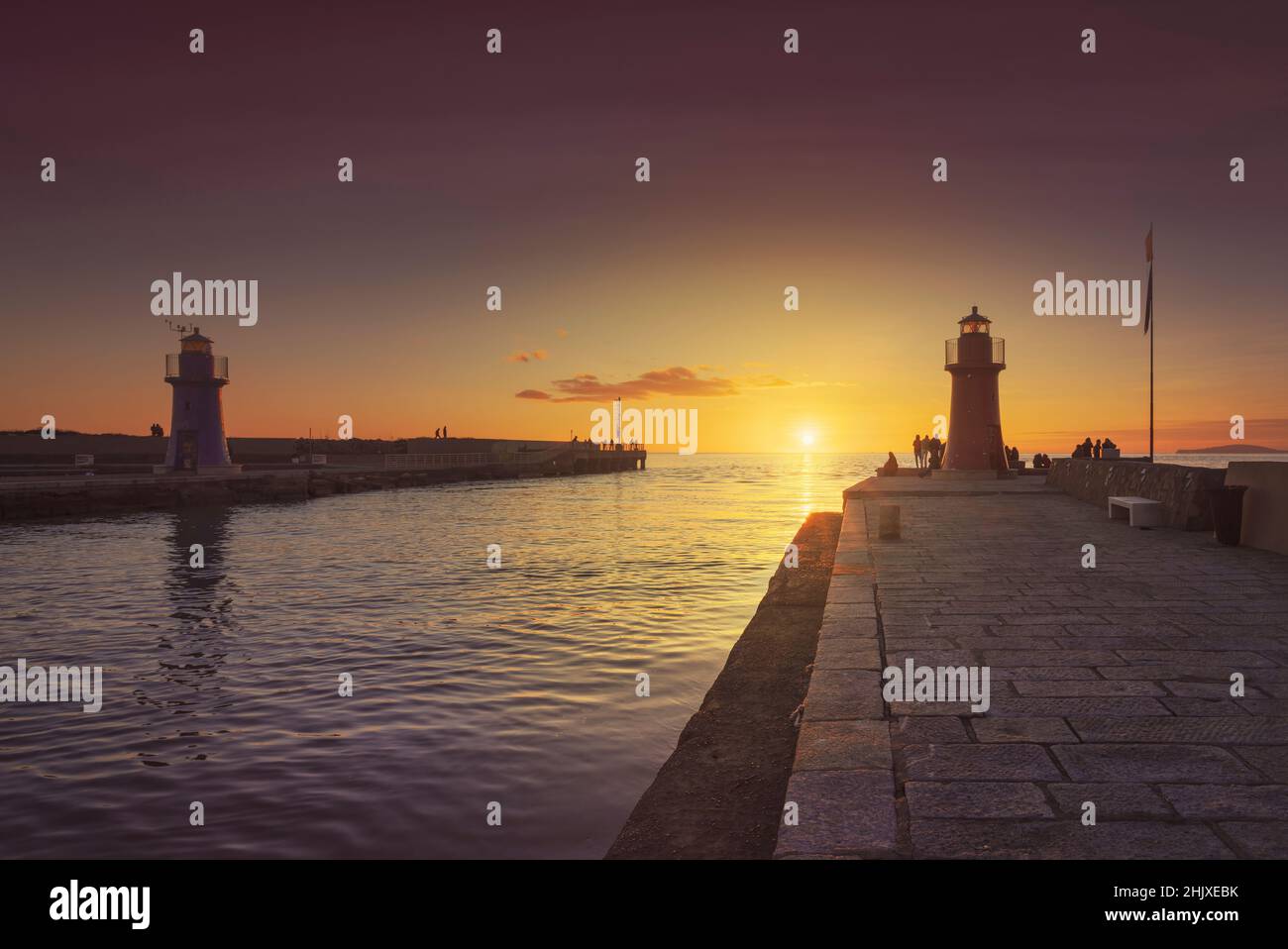 Castiglione della Pescaia, fari rosso e blu al tramonto. Ingresso del porto. Maremma Toscana, Italia Europa. Foto Stock