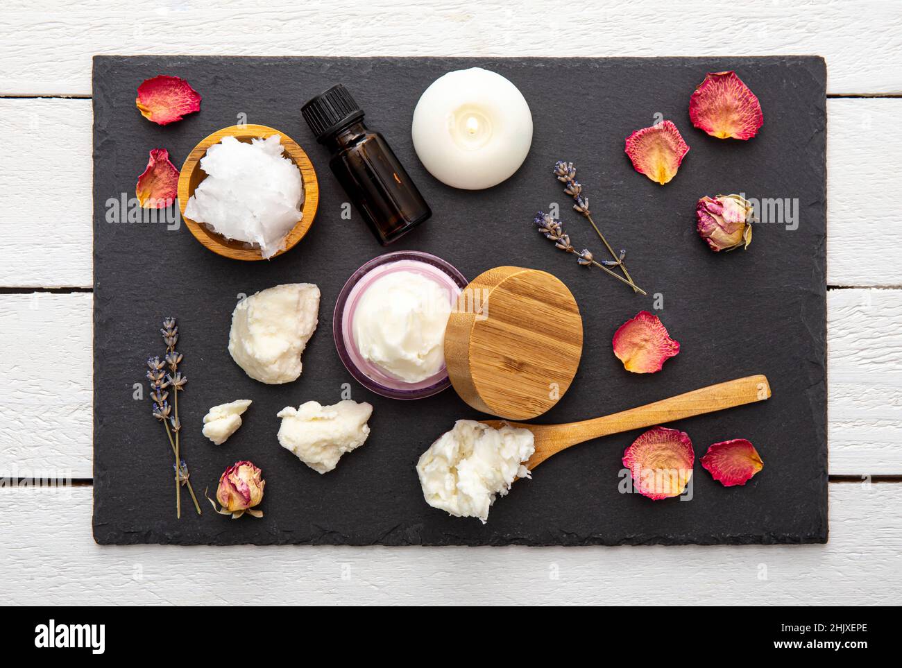 Fare bodywhip anche noto come burro corpo, crema idratante per la cura della pelle. Ingredienti su sfondo legno: Burro di karité, olio di cocco solido, oli essenziali. Foto Stock