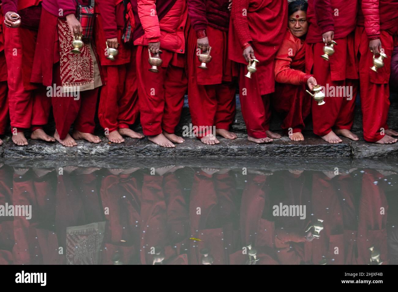 Kathmandu, Nepal. 01st Feb 2022. I devoti che detengono vasi d'acqua riempiono l'acqua del fiume Bagmati, da loro considerato santo, durante la festa di Swasthani Brata Katha. Durante questo festival di un mese, i devoti recitano le Sacre Scritture dedicate alla dea Indù Swasthani e al Dio Indù Lord Shiva. Le donne non sposate pregano per ottenere un buon marito mentre quelle sposate pregano per la longevità dei loro mariti osservando il mese in fretta. (Foto di Prabin Ranabhat/SOPA Images/Sipa USA) Credit: Sipa USA/Alamy Live News Foto Stock