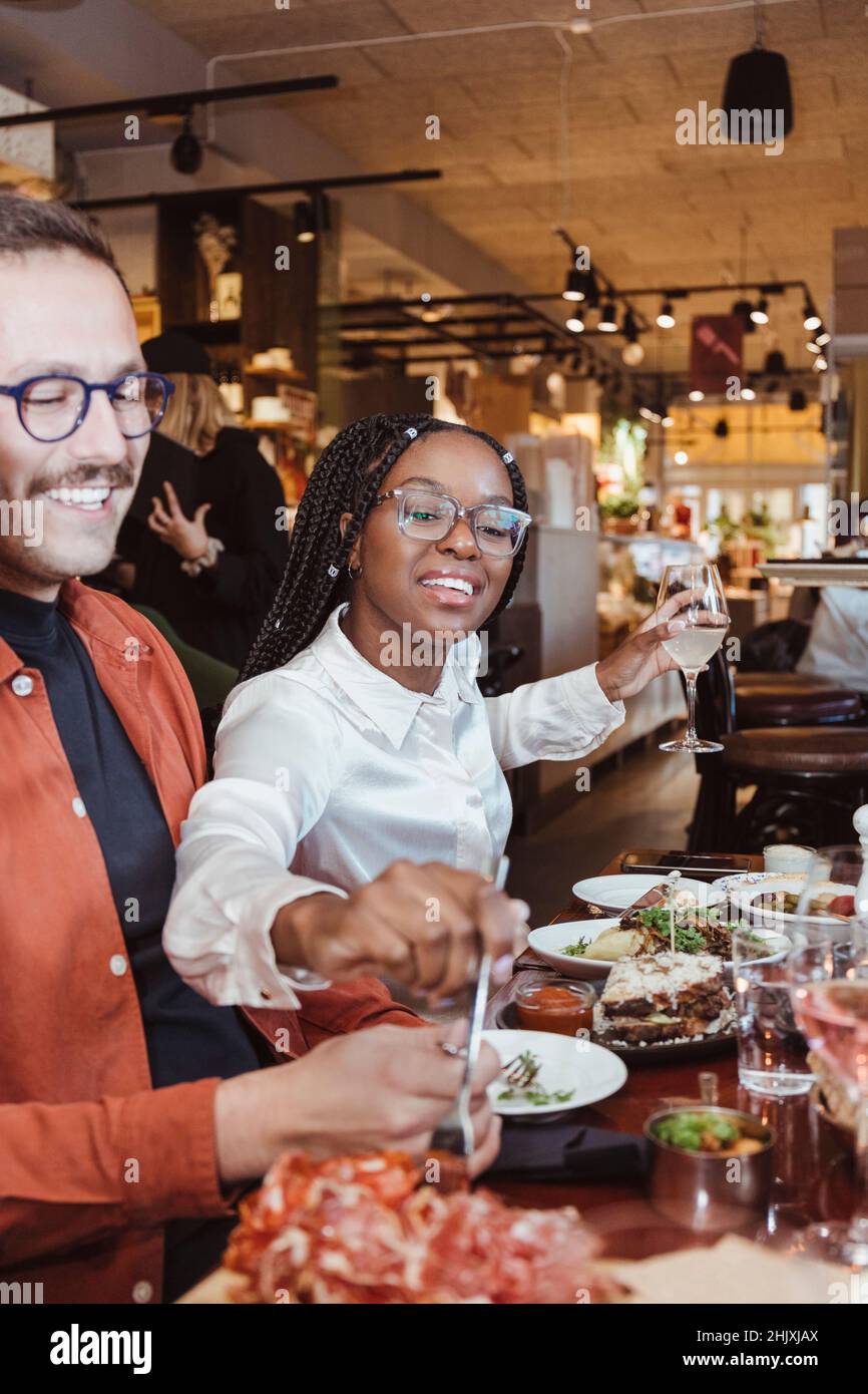 Amici di sesso maschile e femminile che hanno cenato durante la parte al ristorante Foto Stock