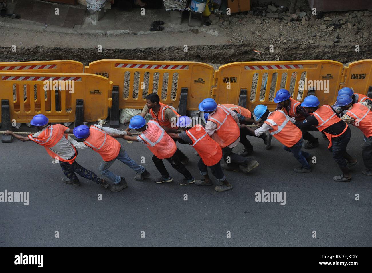 Lavoratori che tirano un cavo in fibra ottica per internet veloce e cavo telefonico Installazione linee elettriche città strada elettricità e comunicazione concetto. Foto Stock
