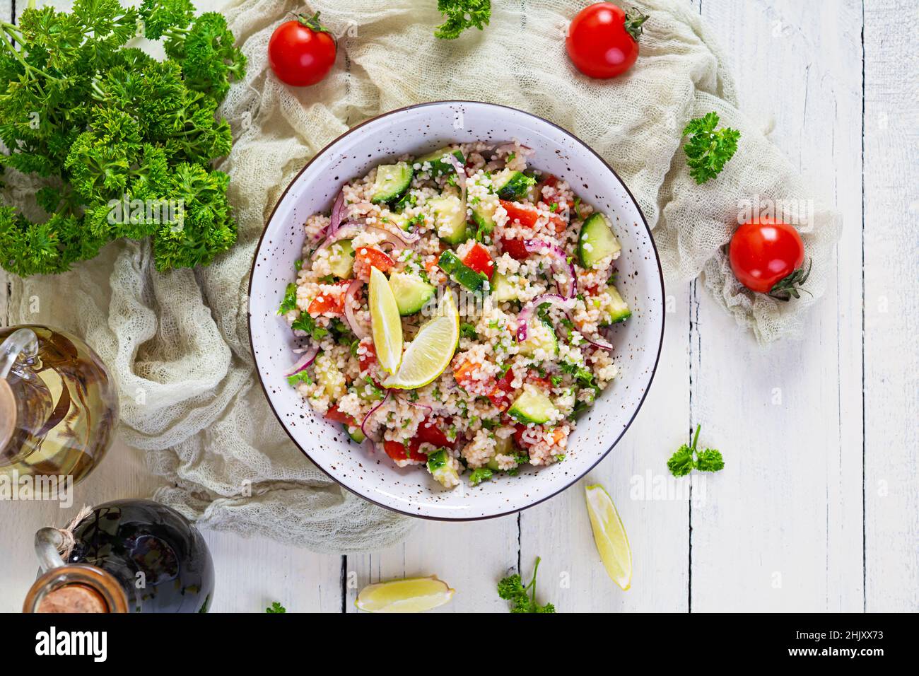 Insalata di tovouleh vegetariana con couscous, prezzemolo, cetriolo, pomodoro. Cucina tradizionale mediorientale o arabica Foto Stock