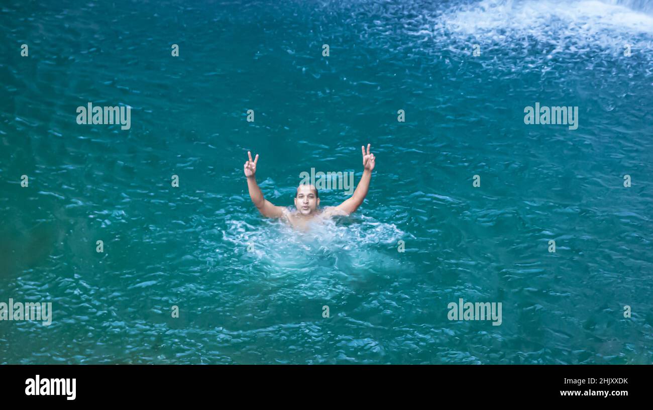 l'uomo giovane che nuota alla cascata naturale acqua blu al mattino dall'immagine dell'angolo superiore è scattato alla caduta di shillong meghalaya india di thangsning. Foto Stock