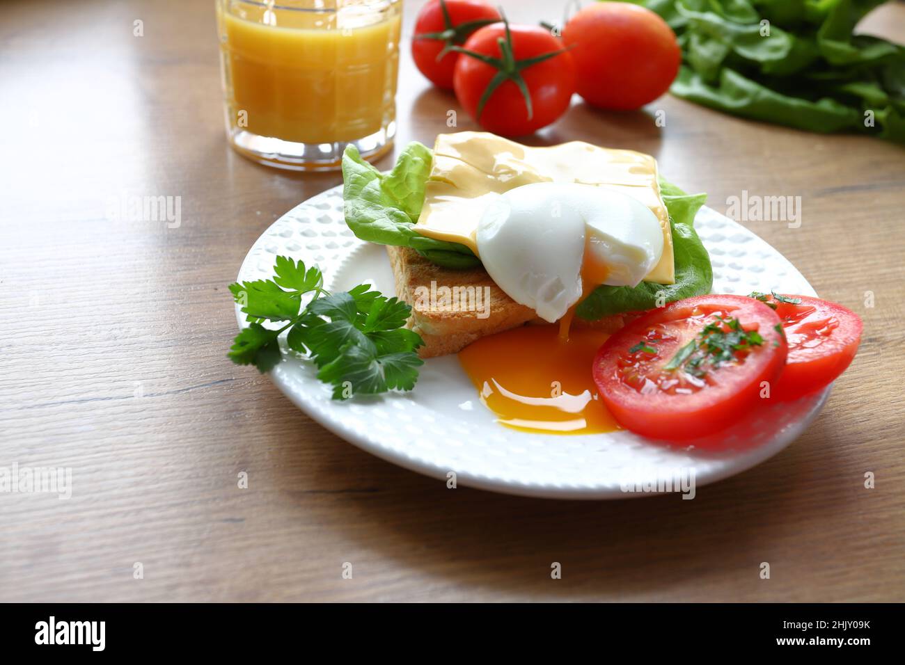 Colazione sana con pane tostato e uova in camicia con insalata verde e pomodori freschi Foto Stock
