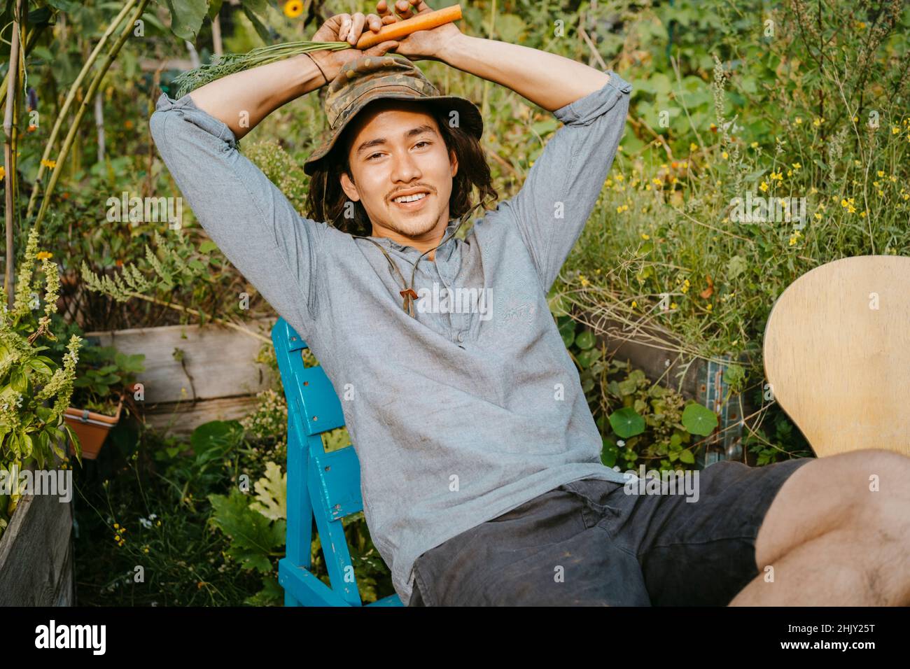 Ritratto di agricoltore maschile seduto in giardino comunitario Foto Stock
